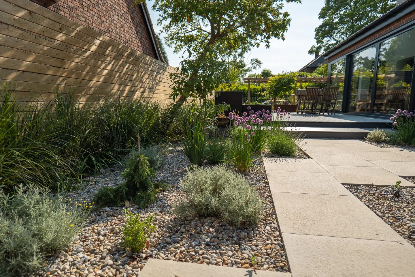 Mediterranean planting, bespoke horizontally-boarded fence and Anemanthele lessoniana hedge in Alwoodley