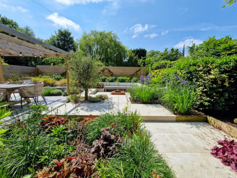 Contemporary garden design - Courtyard garden with varied planting and trees in the distance in Oulton. Yorkshire Gardens, Leeds
